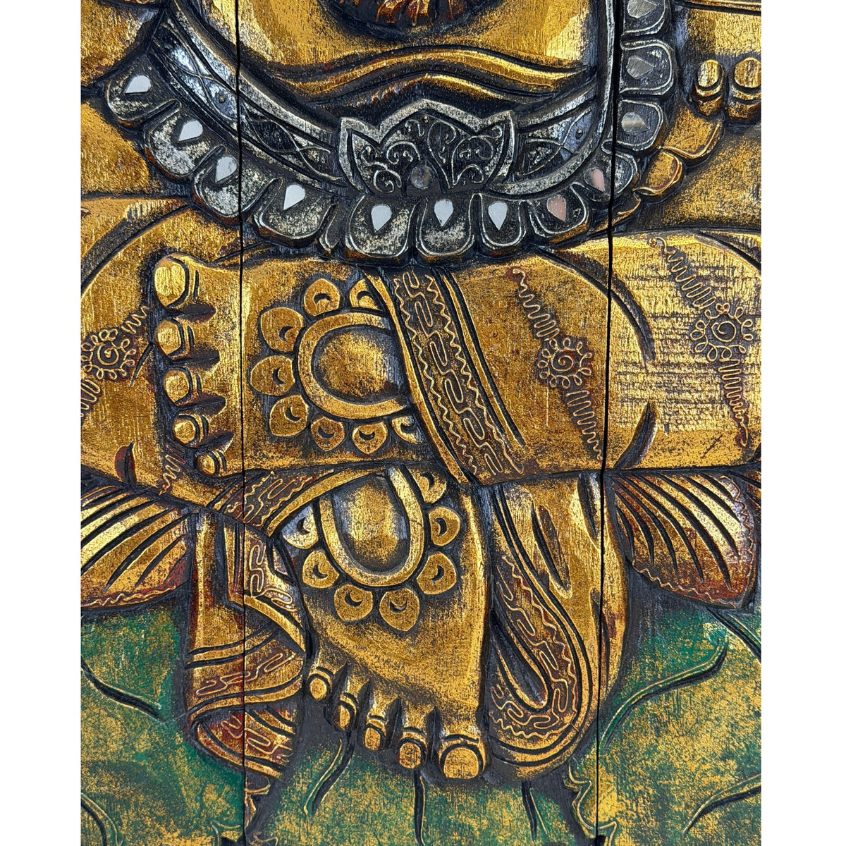 Ganeshas Füße über dem Lotussitz; darüber ein verzierter Gürtel mit kleinen spiegelnden Einlagen.