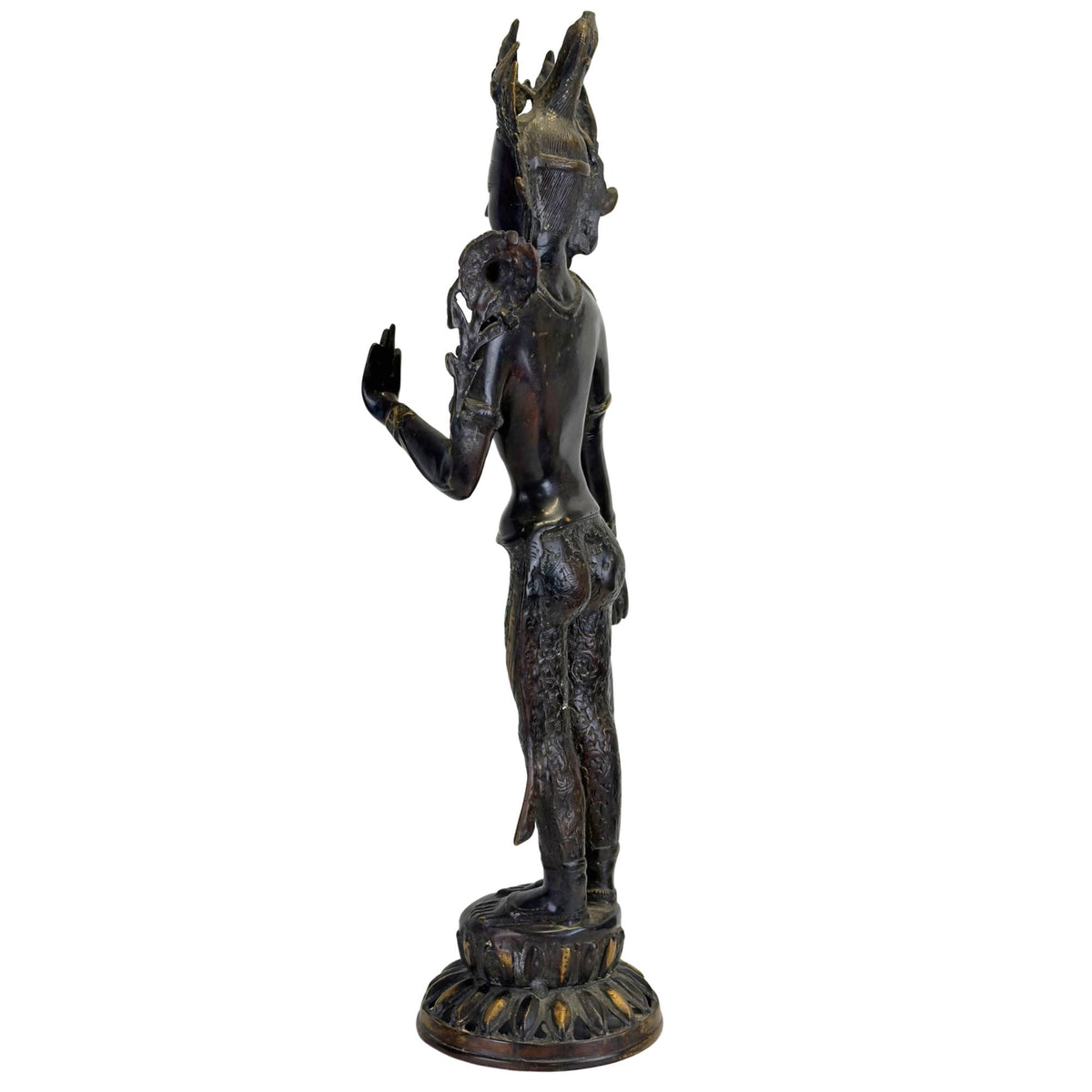 Oblique rear view of an antique bronze Green Tara from Nepal with openwork crown, lotus stem, black Newar patina, and fire-gilded accents.
