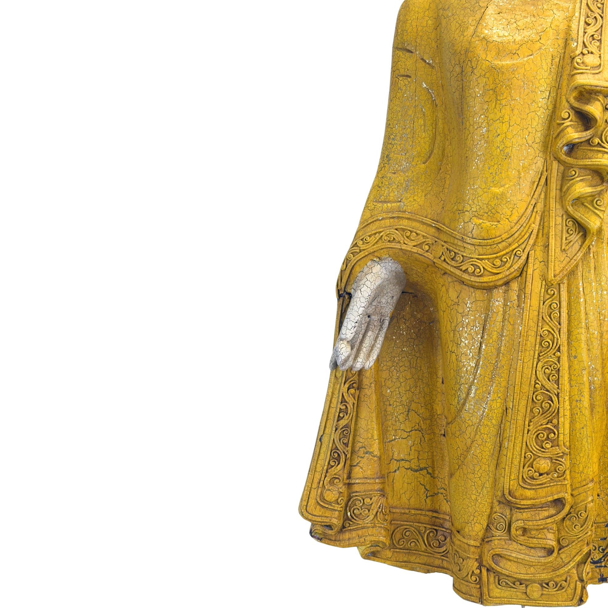 Nahaufnahme der rechten Hand Buddhas, die das Gewand hält, mit der feinen, knisternden Textur auf Haut und Kleidung.