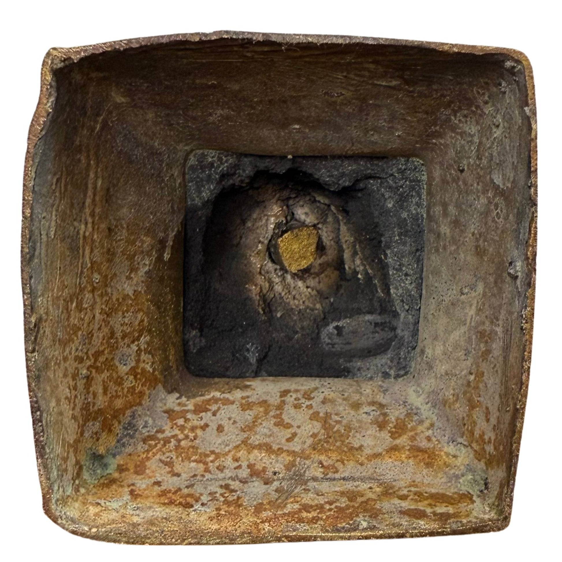 Forensische Beweise von der Unterseite mit versteinertem Gusskern und der goldenen rituellen Ablagerung.