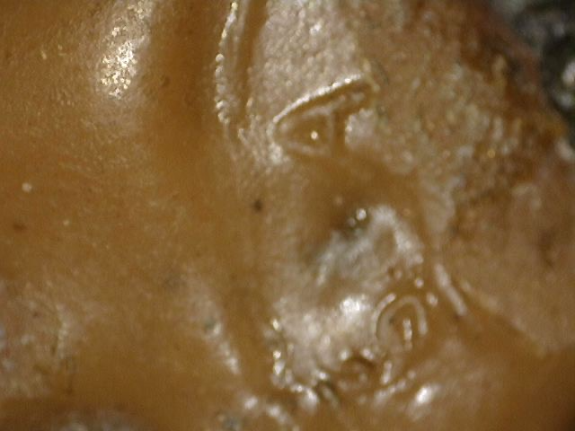 Detail eines alten Lack- oder Wachsstempels in der Haarstruktur einer chinesischen Buddha-Statue