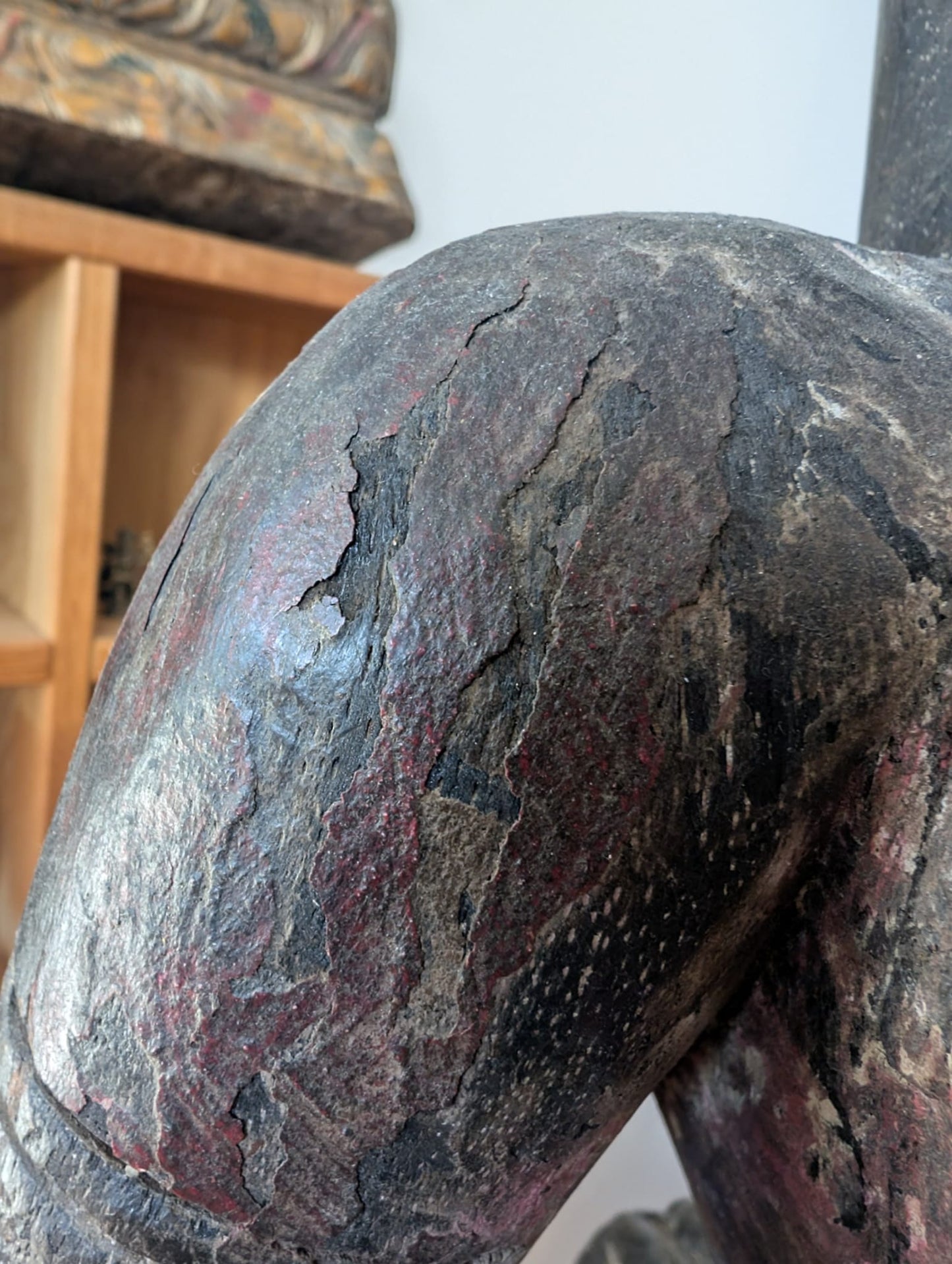 Detail einer hölzernen Lakshmi-Statue aus Nepal mit Textur, Patina und Craquelé in der Oberfläche