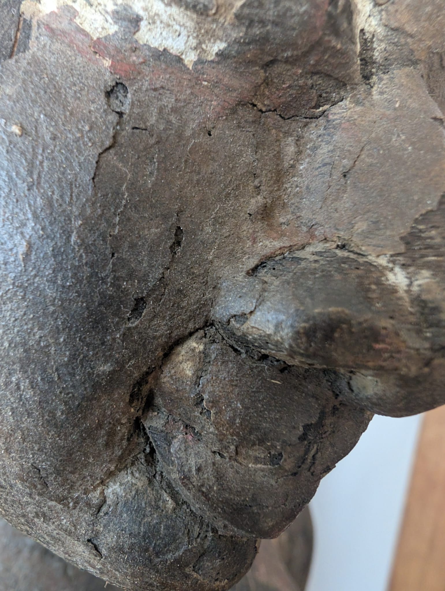 Detail einer hölzernen Lakshmi-Statue aus Nepal mit alten Farbschichten und tiefen Schnitzereien