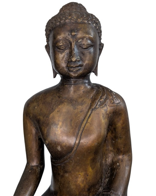 Antike Buddha-Statue auf einem traditionellen Lotusthron.