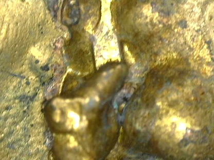 Mikroskopisches Detail der historischen Vergoldung auf einem japanischen bronzenen Buddha