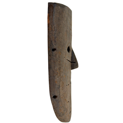 Linkes Profil der nepalesischen Holzmaske mit vorspringender Nase und Randbohrungen