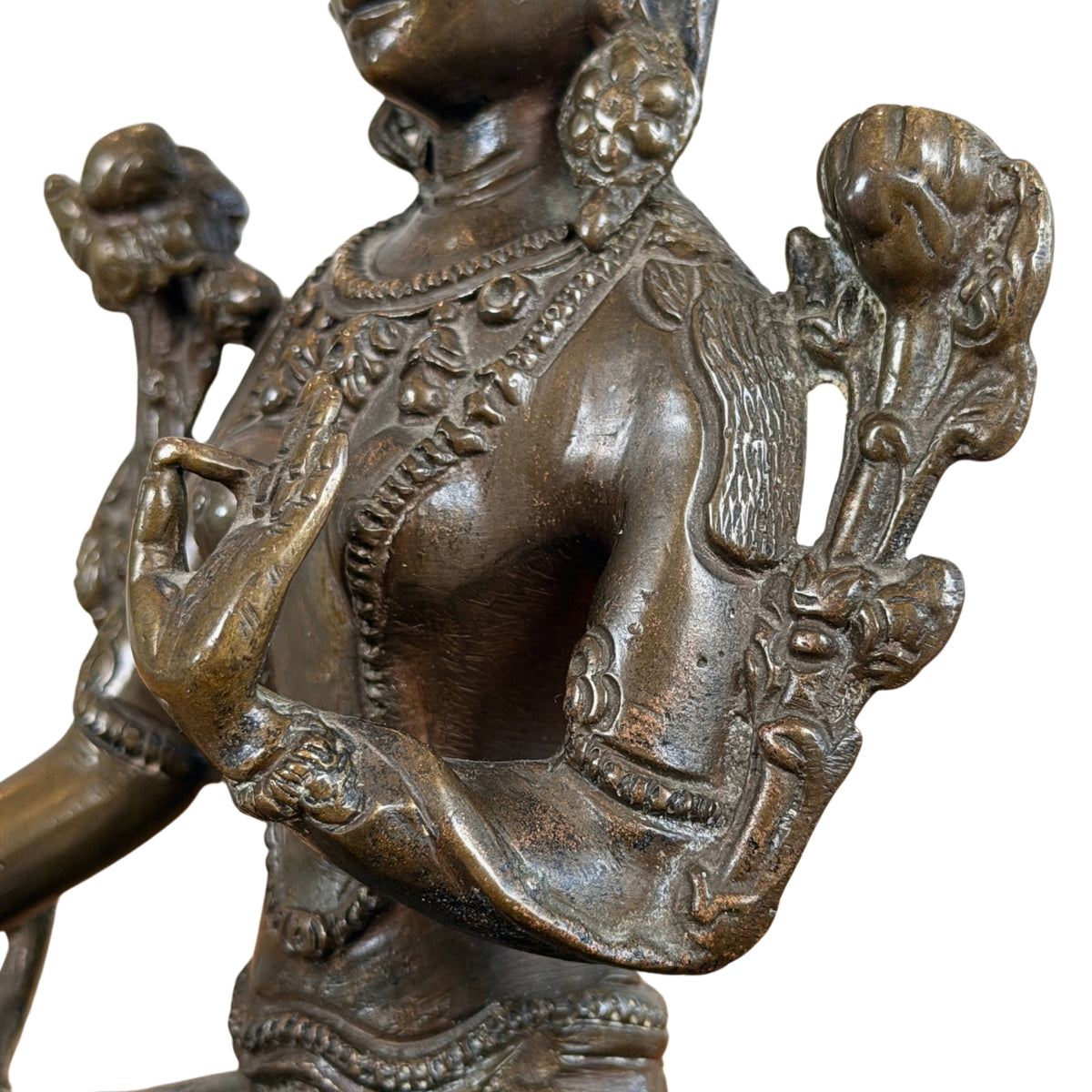 Bovenlijf met halssieraden, vitarka-hand en de twee utpala-lotussen, detail