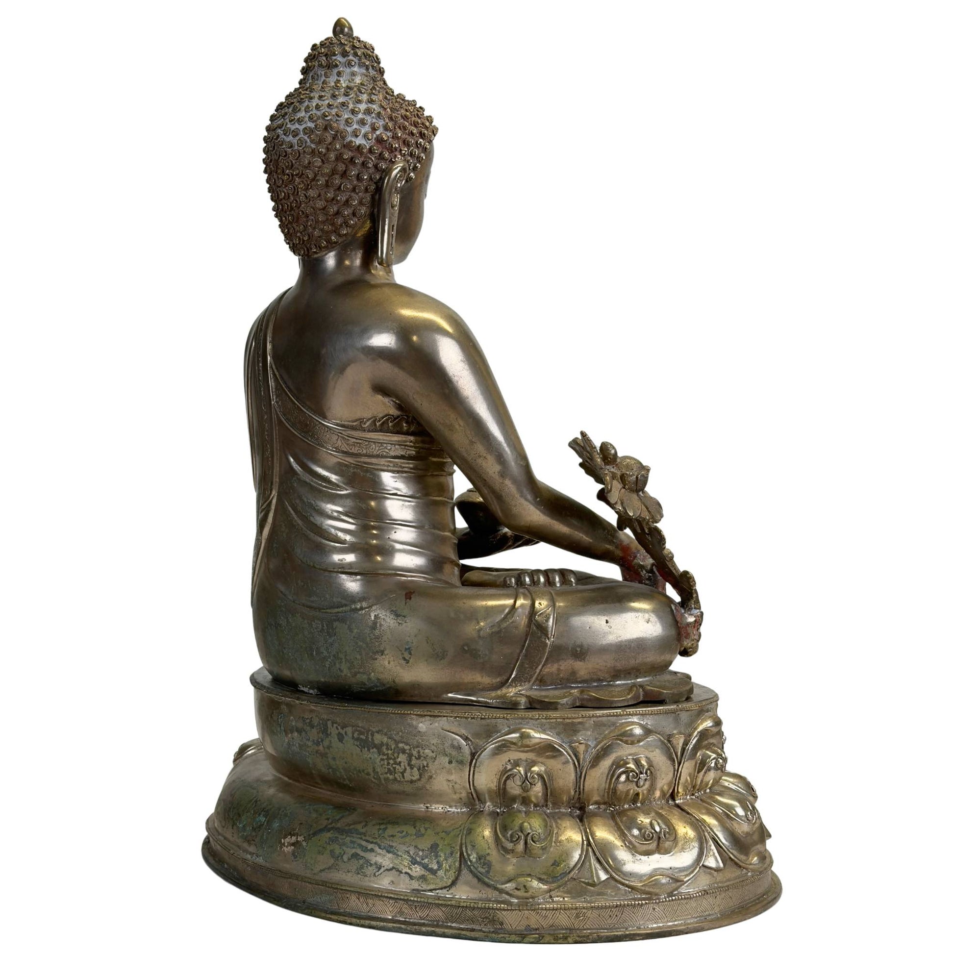 Dreiviertel-Rückansicht eines antiken Newar Bhaisajyaguru aus versilberter Bronze mit reich verziertem Gewand, natürlicher Patina und monumentalem Doppellotusthron.
