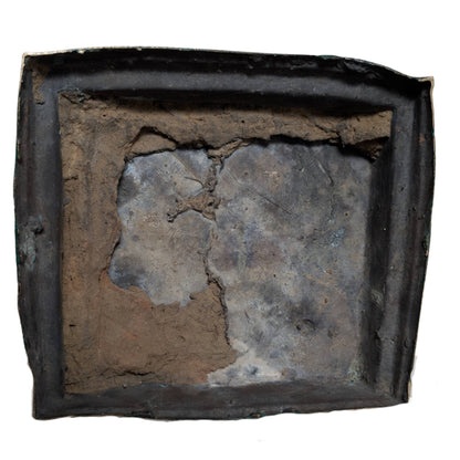 Unterseite des Bronze‑Gussstücks mit Resten des Gusskerns