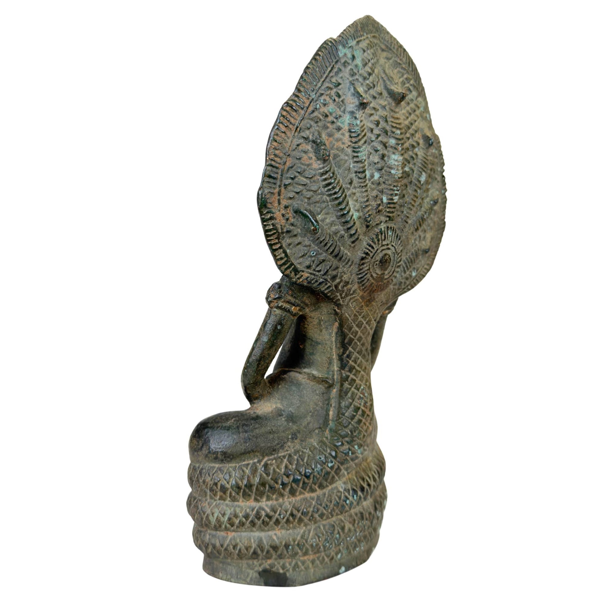 Hohler Sockel der massiven Bronzestatue mit Mineralablagerungen.