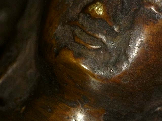 Mikroskopische Aufnahme von Patinaschichten auf einer Buddha-Statue aus Bronze aus dem Himalaya mit Dhyana Mudra