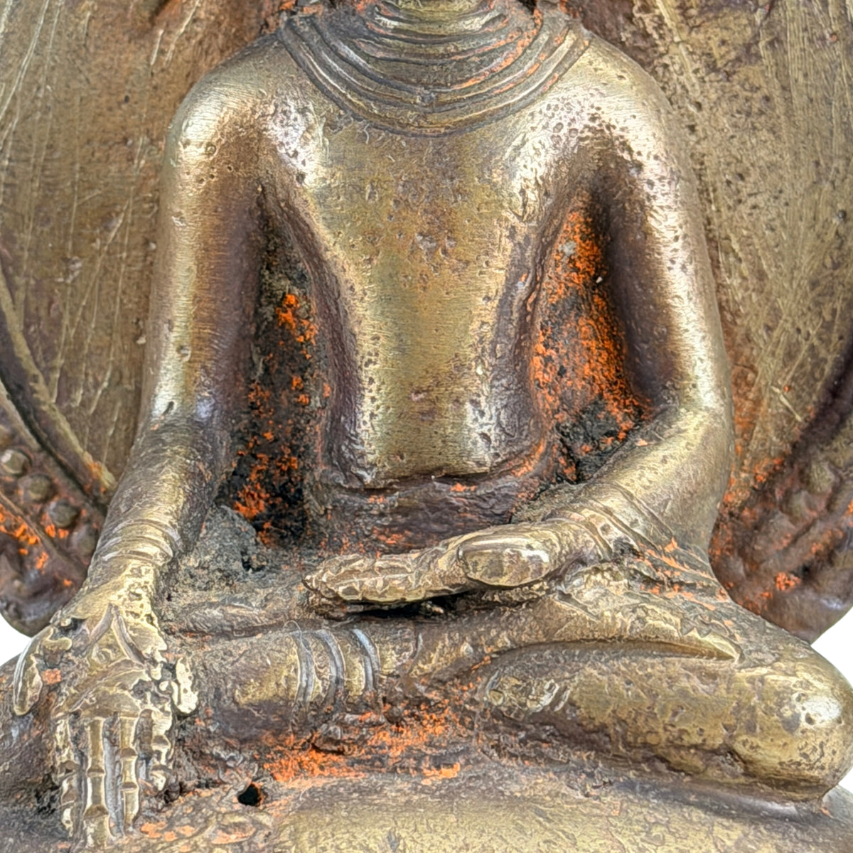 Detail of the varada mudra, left hand in the lap and patinated bronze surface