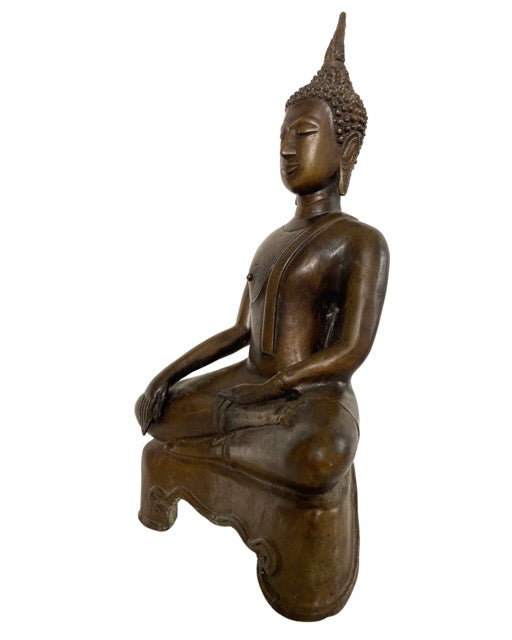 Thailändischer Buddha aus Bronze sitzt in Bhumisparsha-Pose mit friedlichem Gesichtsausdruck.