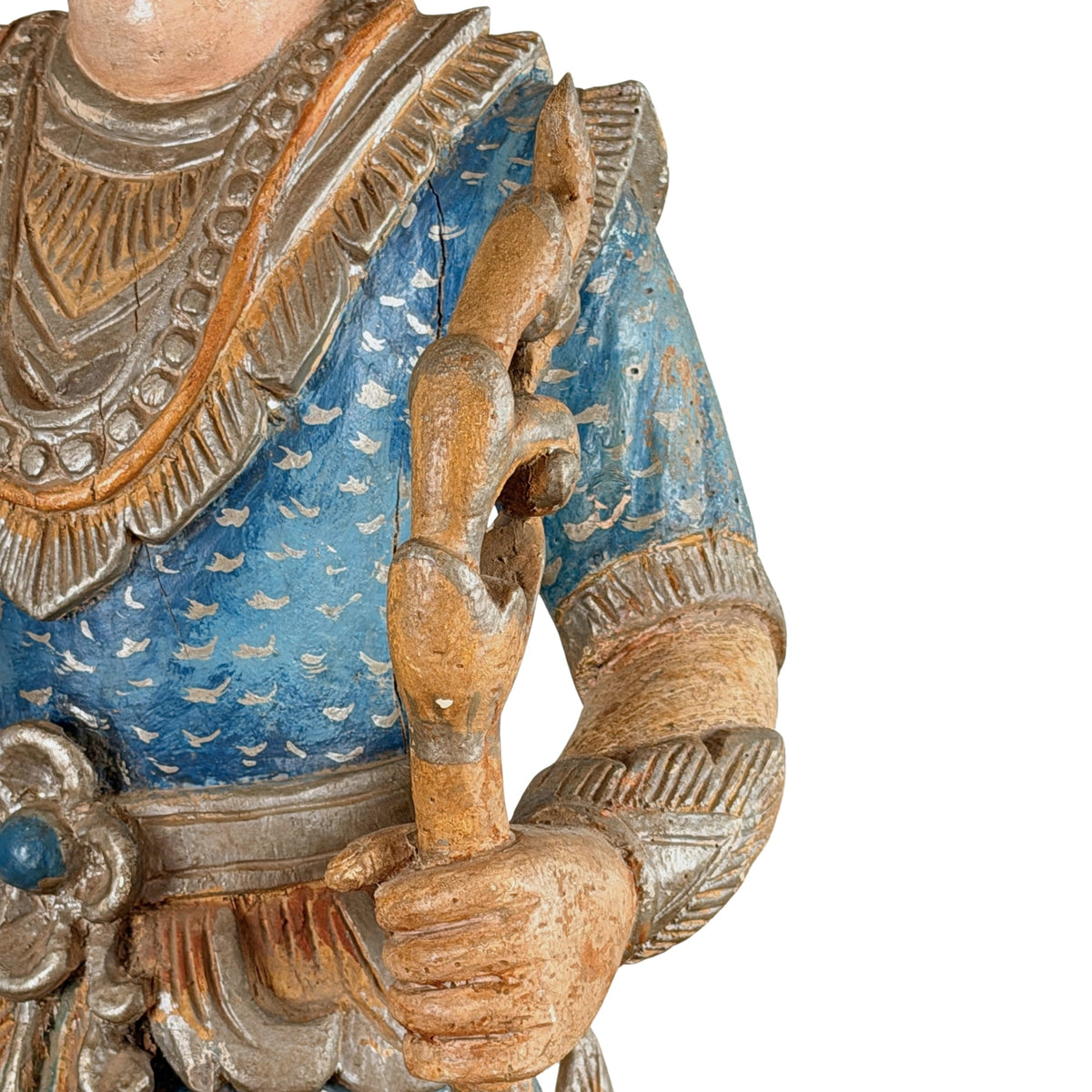 Teakholz-Wächterfigur von vorn: mehrlagiger Kragen, blauer Oberkörper und die Hand am geschnitzten Stab