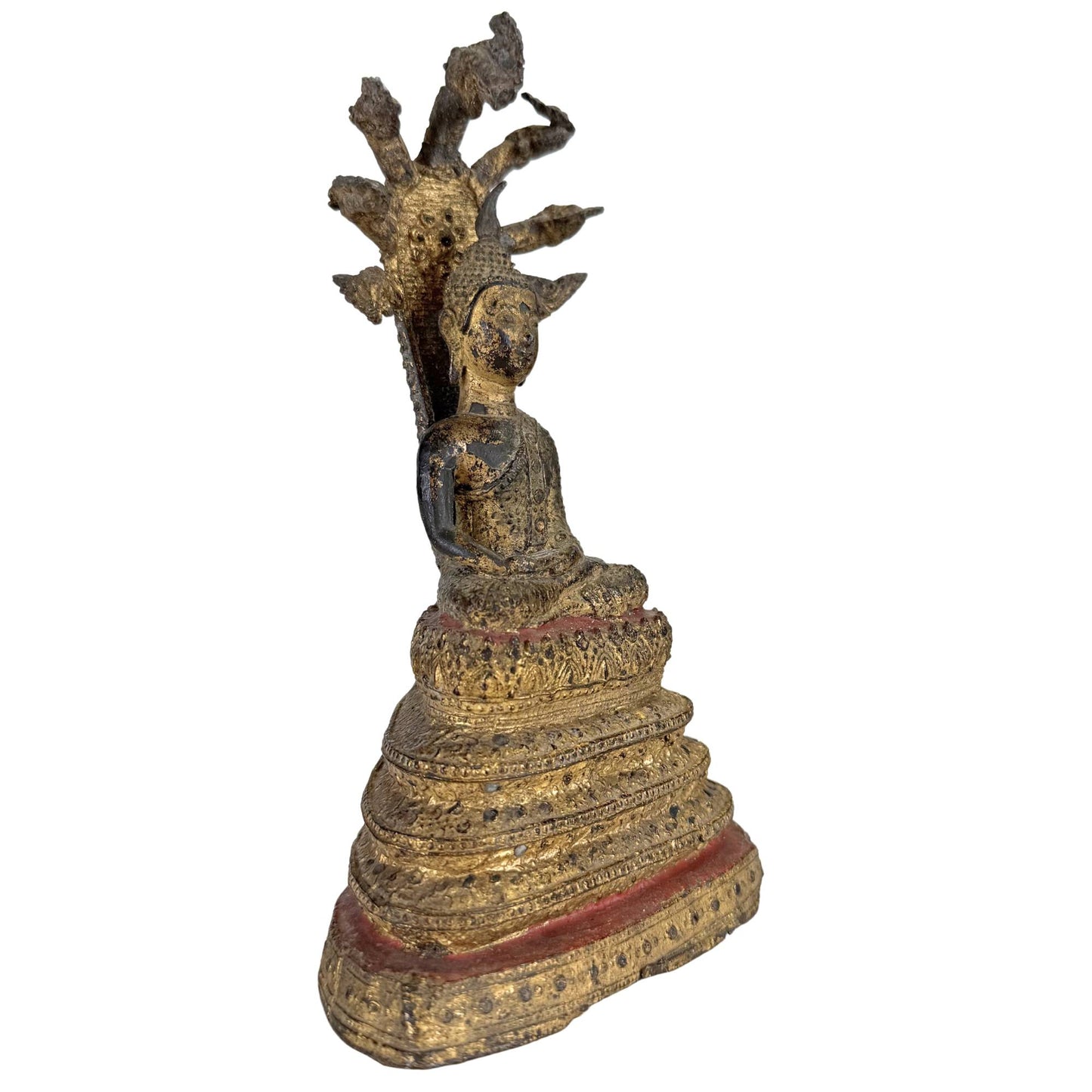 Seitenansicht eines antiken thailändischen Naga-Buddha mit vergoldeter Oberfläche und mehrköpfiger Schlange