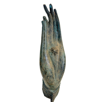 Detail der thailändischen Bronze-Buddhahand mit zentralem Blütenchakra und langen Fingern