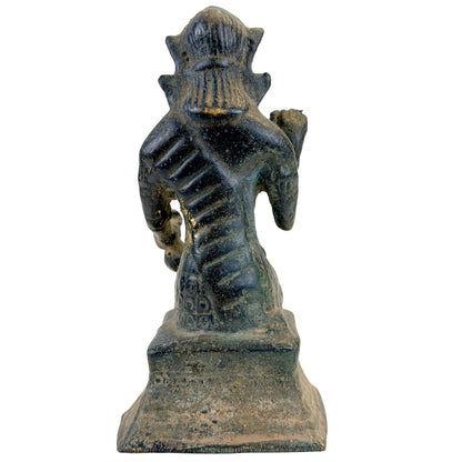 Rückansicht der thailändischen Bronzefigur Nang Kwak auf ornamentiertem Sockel.