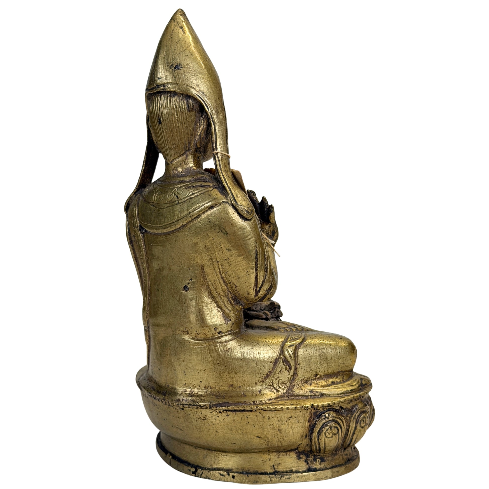 Rückseite der Gelug-Lamafigur mit gravierten Gewandsäumen und langen Mützenlaschen
