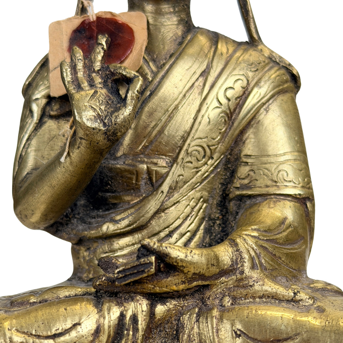 Nahaufnahme von Lehrgestus und gebundenem Manuskript der tibetischen Gelug-Figur
