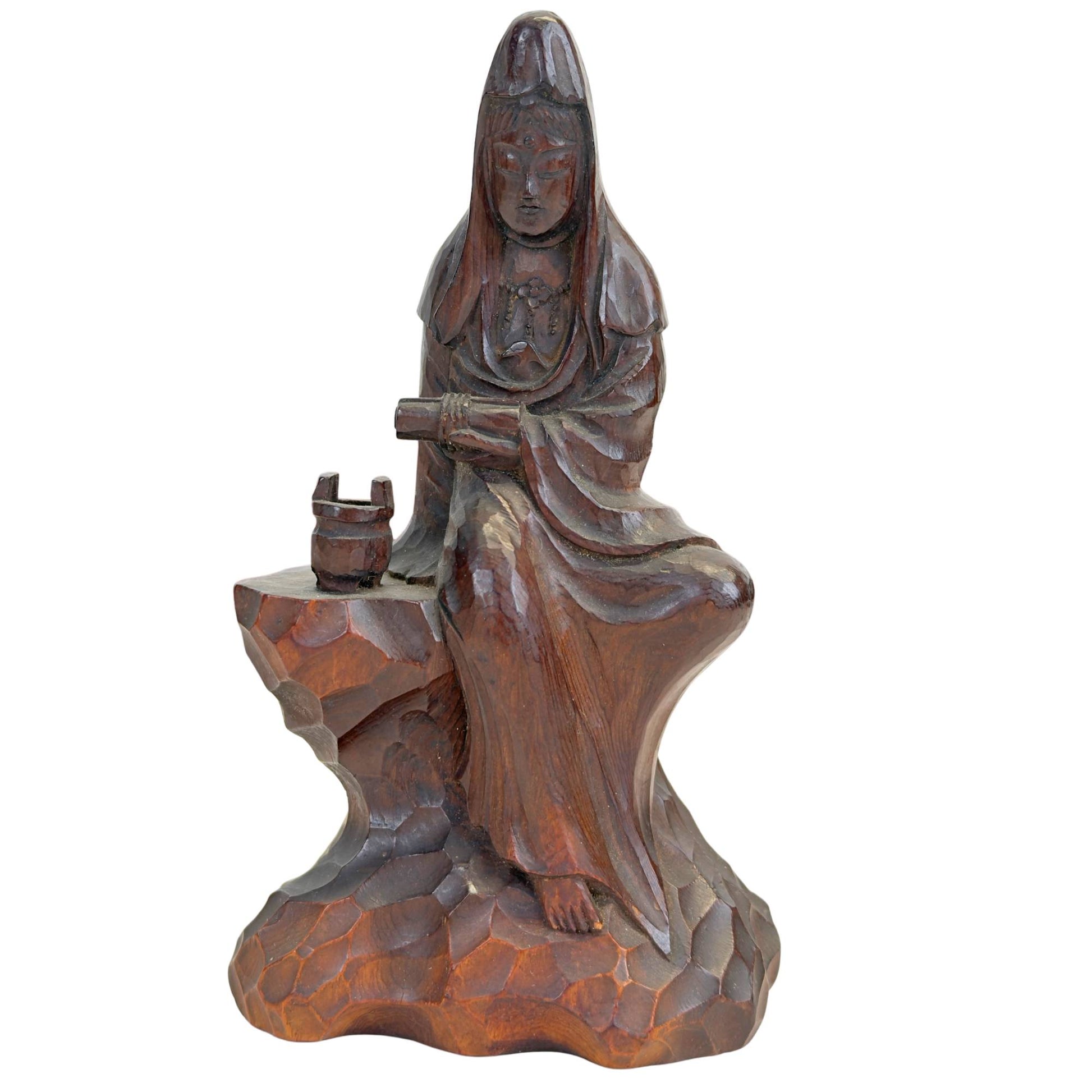 Vorderansicht der handgeschnitzten japanischen Kannon (Guanyin) aus Holz, sitzend auf einem Felsensockel, mit einem Opfergefäß in kastanienbrauner Patina.