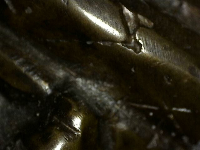 Detail von fragmentarischen Blattgoldresten, die in die Patina einer Khmer-Bronzebüste von Vishnu eingebettet sind