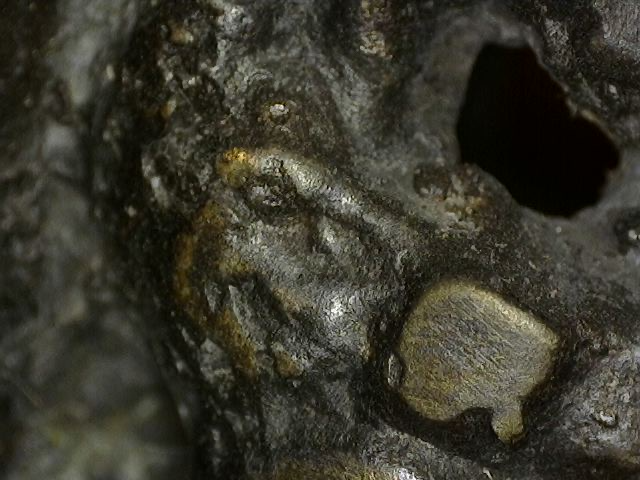 Mikroskopische Detailaufnahme von abgerundeten Abnutzungsspuren der Feuervergoldung an einer historischen Vishnu-Büste