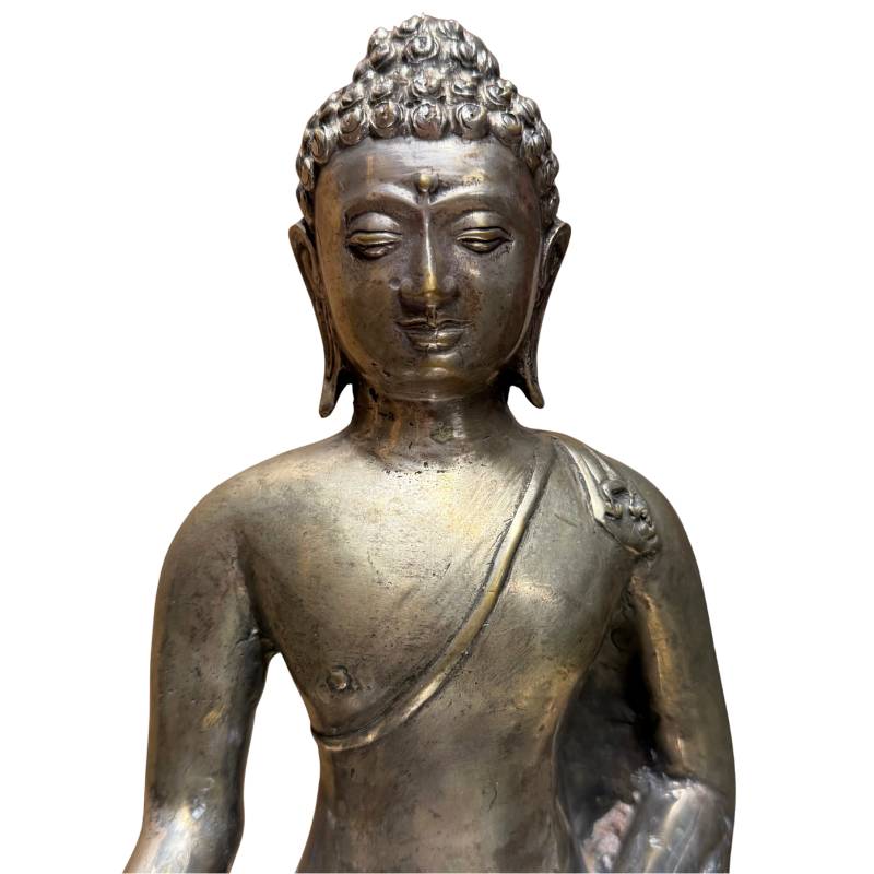 Eine Buddha-Figur aus silberfarbenem Messing mit natürlichen Gebrauchsspuren weist an den Knien einen goldenen Kern auf.